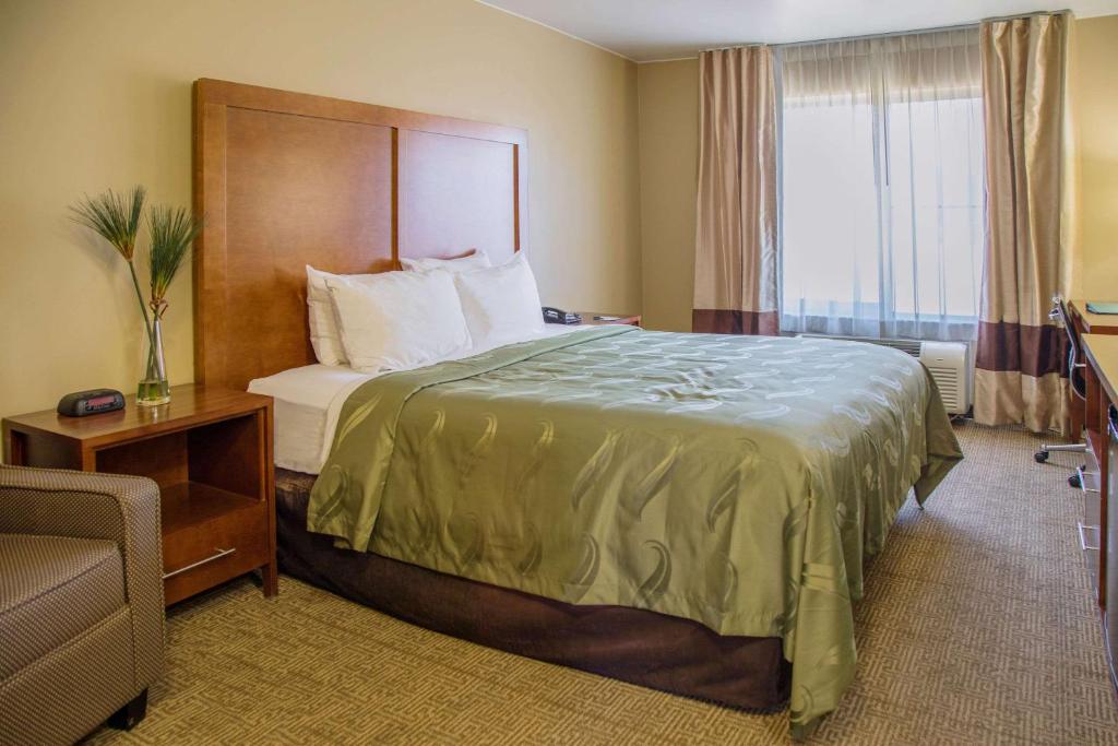 a hotel room with a bed and a window at Quality Inn Merced Gateway to Yosemite in Merced