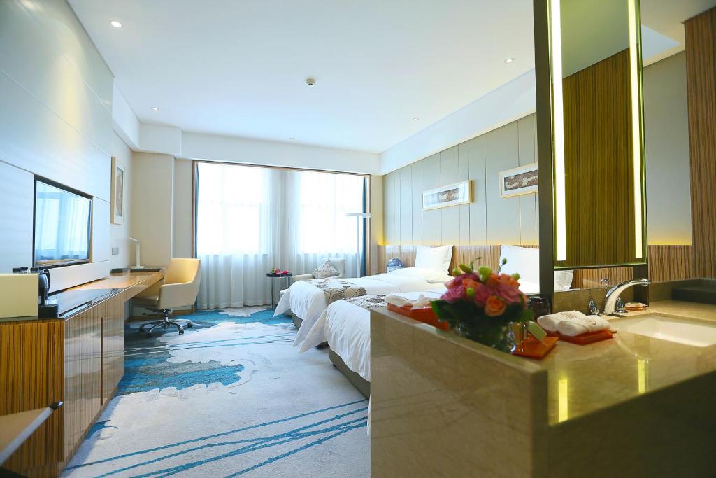 a hotel room with a bed and a sink at Yinchuan Xifujing Hotel in Yinchuan