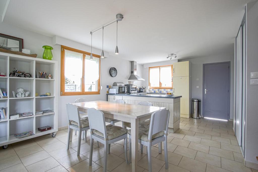 a kitchen with a table and chairs in a room at Les Costils in Saint-Laurent-sur-Mer
