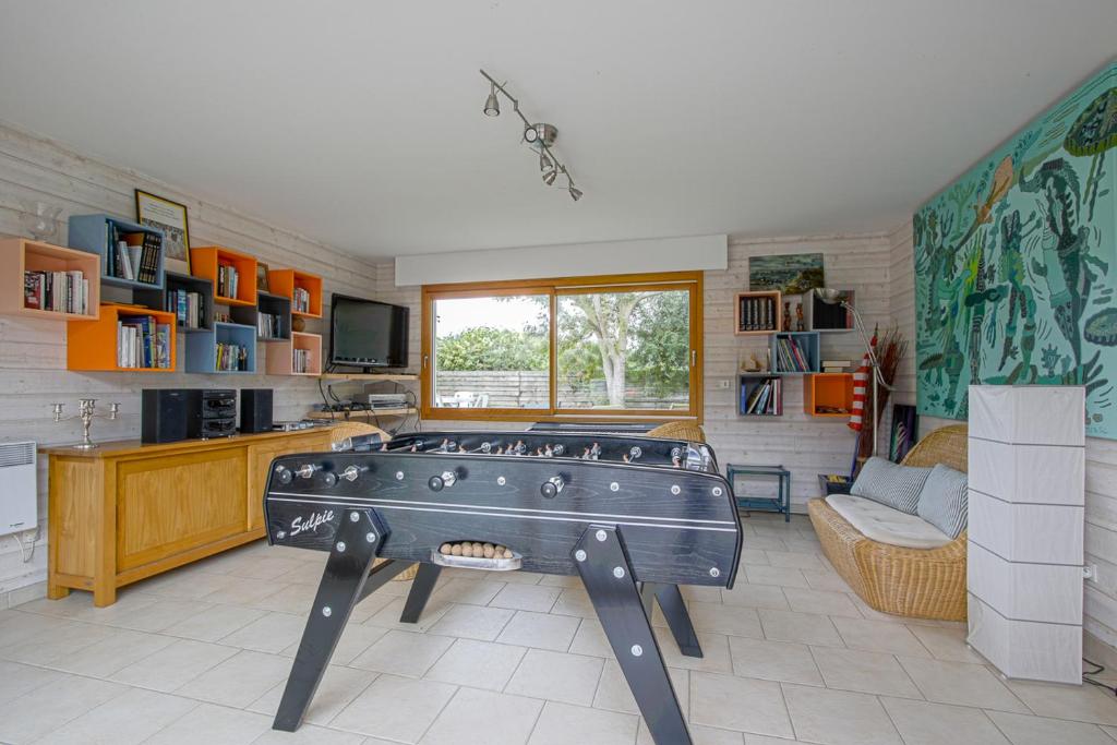 a living room with a pool table in the middle of it at Les Costils in Saint-Laurent-sur-Mer