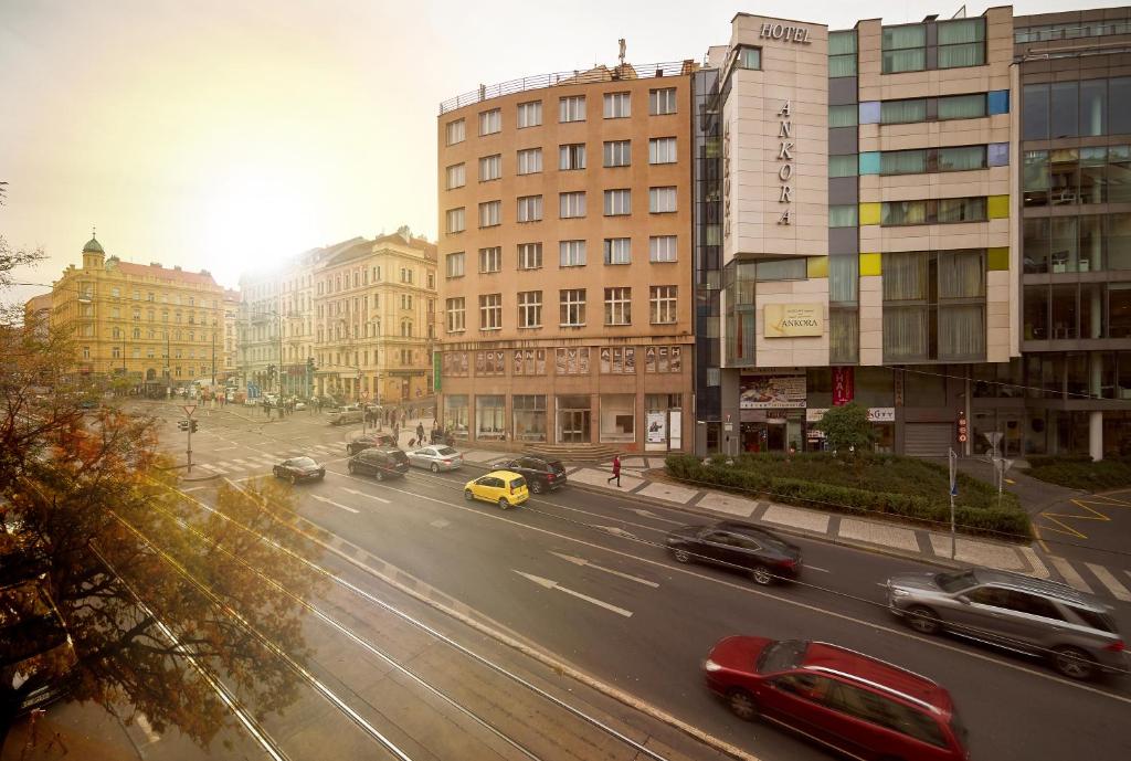 una concurrida calle de la ciudad con coches conduciendo por la carretera en Hotel Ankora en Praga