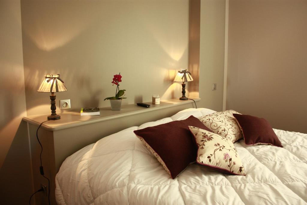a bedroom with a bed with two lamps on it at La Maison d'Adelaïde in Saint-Flour