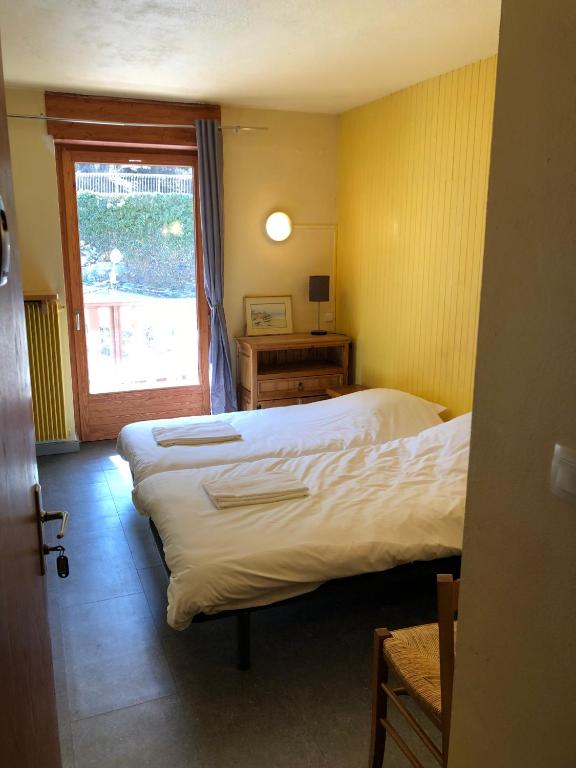 une chambre d'hôtel avec deux lits et une fenêtre dans l'établissement Royal 513, à Brides-les-Bains