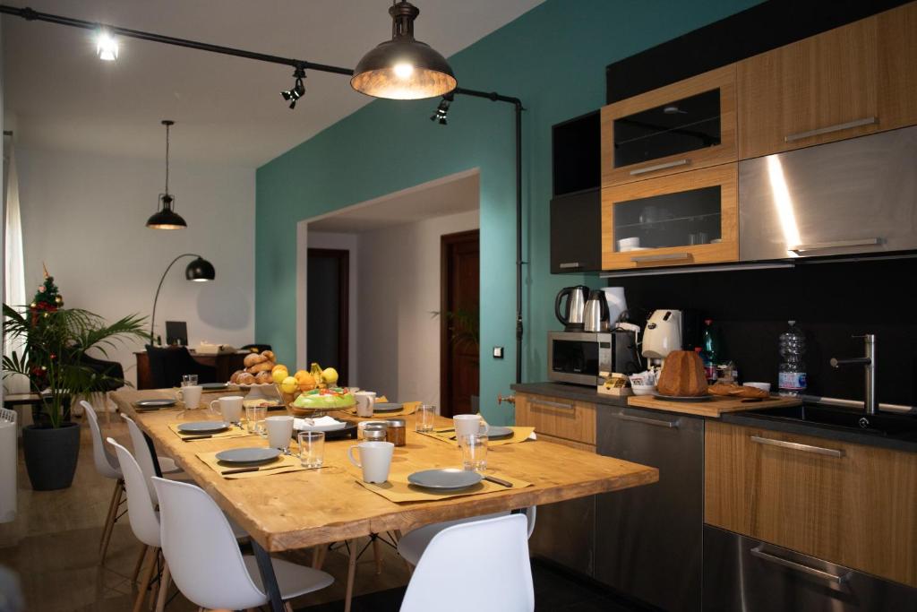 a kitchen with a wooden table with white chairs at Panoramica dei Templi B&B in Agrigento