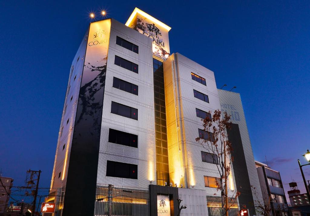 a tall white building with lights on top of it at HOTEL 小粋 -coiki- in Hiroshima