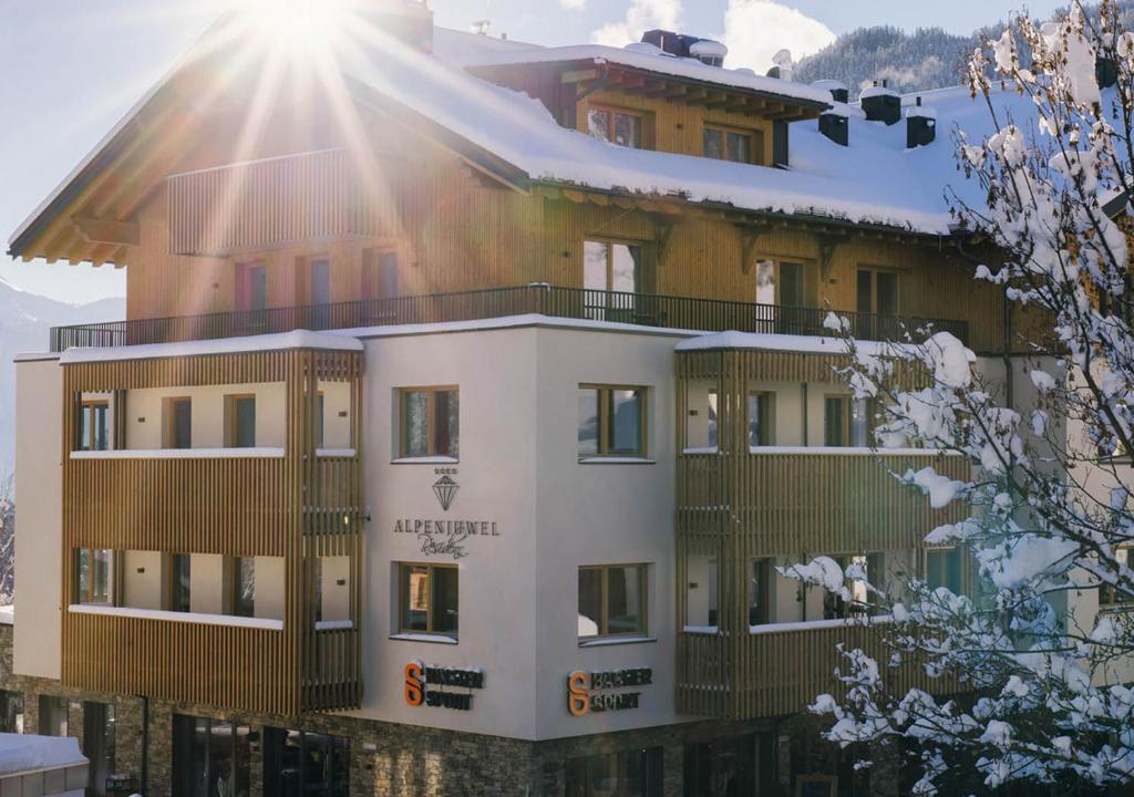 a building with the sun shining on it at Hotel Garni Alpenjuwel Residenz in Serfaus
