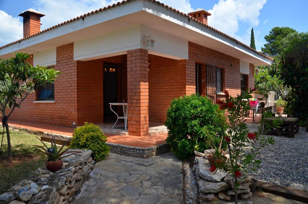 una pequeña casa de ladrillo con porche delantero en Villa Font, en L'Ametlla de Mar