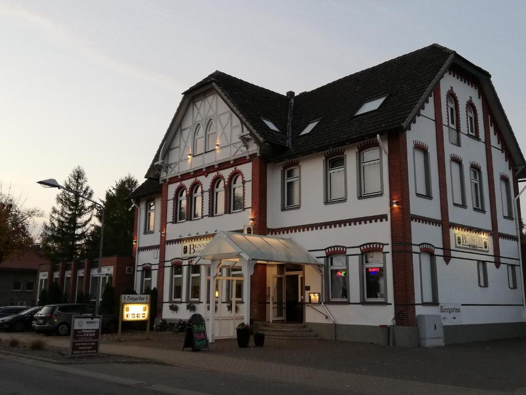 a large white and red building on a street at Bennetts Restaurant und Hotel in Wittingen