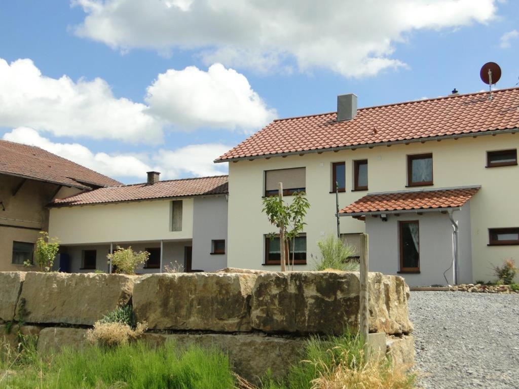 una casa con una valla de piedra delante de ella en Ferienwohnung 4 in den Krautgärten, en Ochsenburg