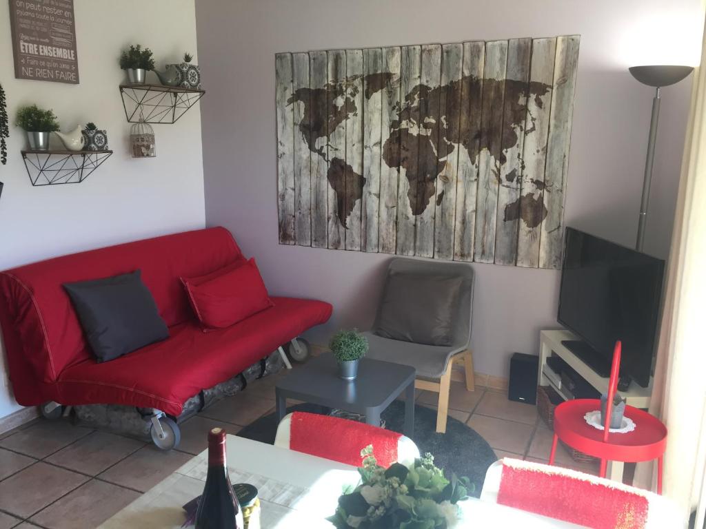a living room with a red couch and a map on the wall at Clos des Templiers in Saint-Rémy-de-Provence