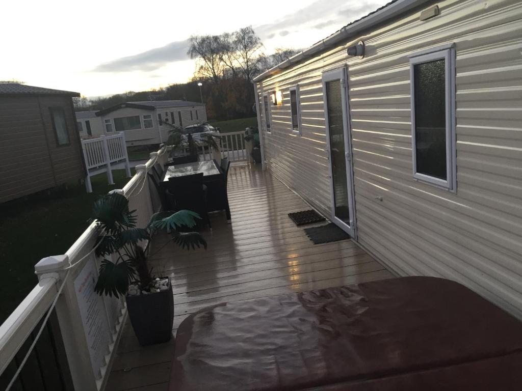 a porch of a house with a deck at 3 bedroom 8 berth standard caravans with Hot Tub,Mountain Bikes in Tattershall