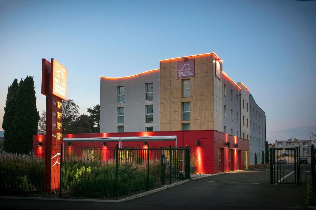 un edificio con luces rojas delante de él en Hotel Clermont Estaing en Clermont-Ferrand