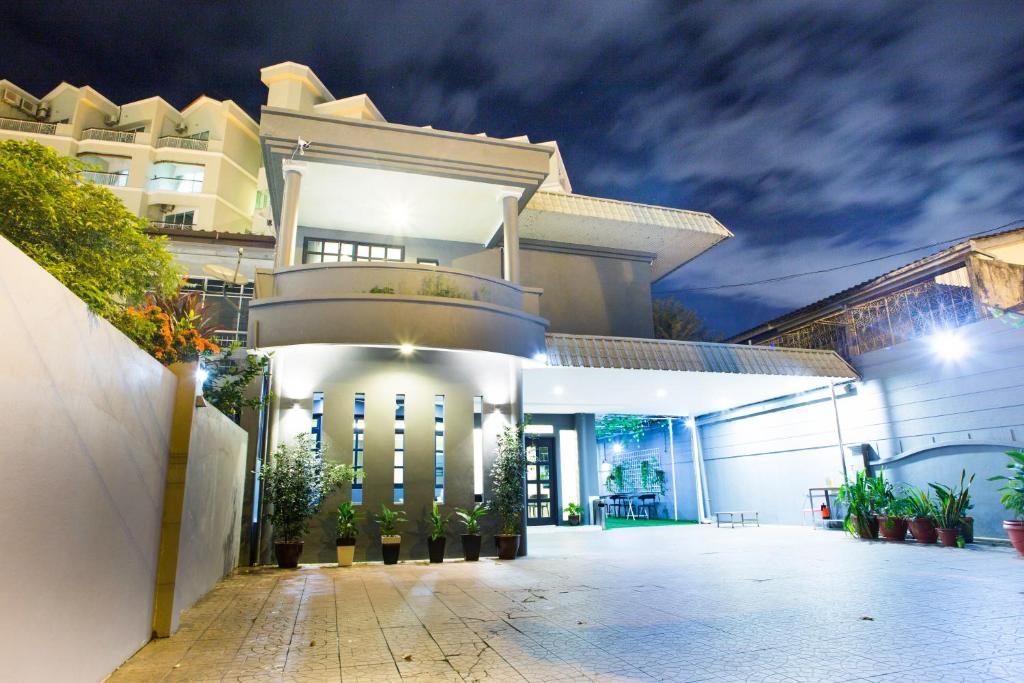 um grande edifício branco com um pátio à noite em G Beach Front Villa em Batu Ferringhi