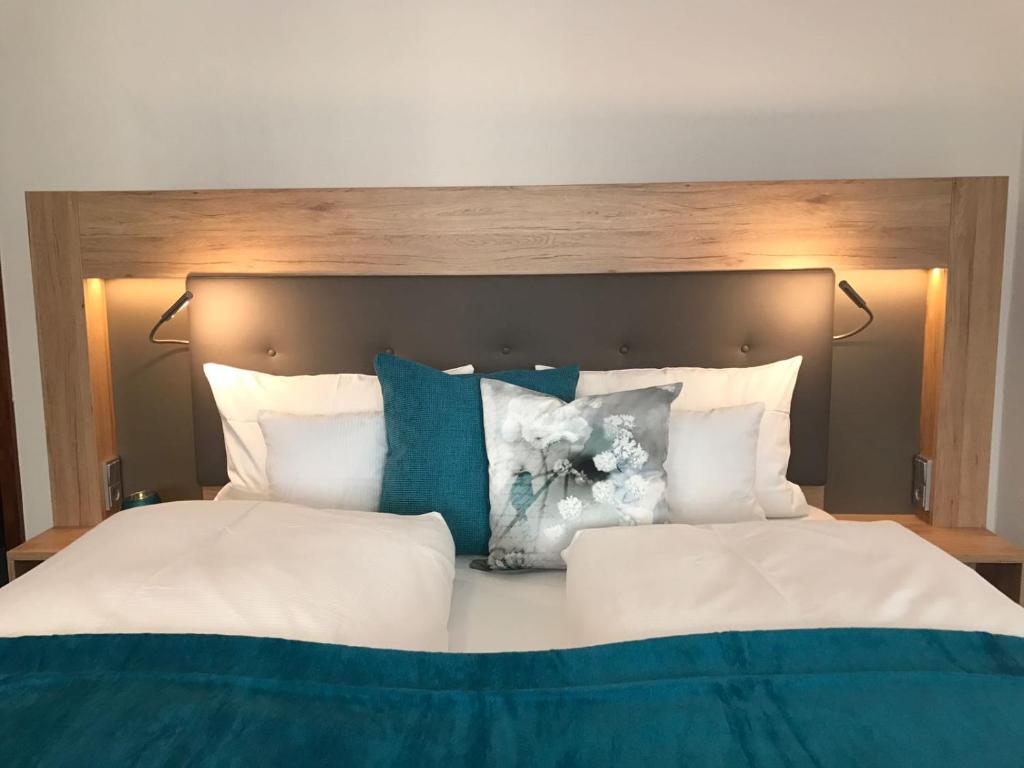 Una cama con almohadas azules y blancas. en Hotel Kronprinz, en Kulmbach