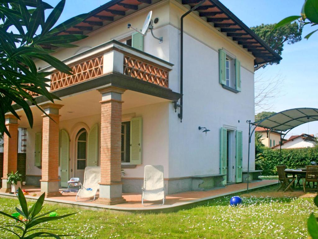 a house with a balcony and chairs in the yard at Villa Marzia by Interhome in Forte dei Marmi