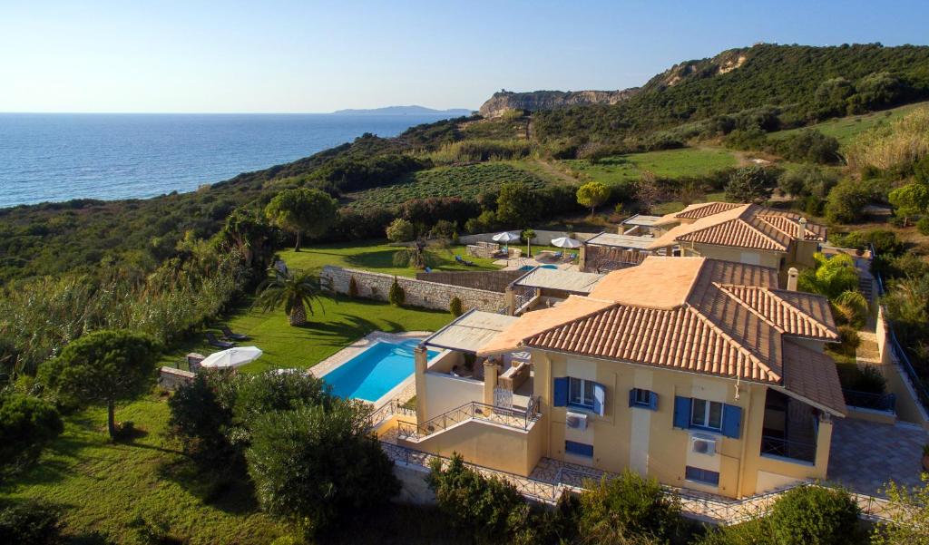 an aerial view of a house with a swimming pool and the ocean at Panorama Villas in Arillas