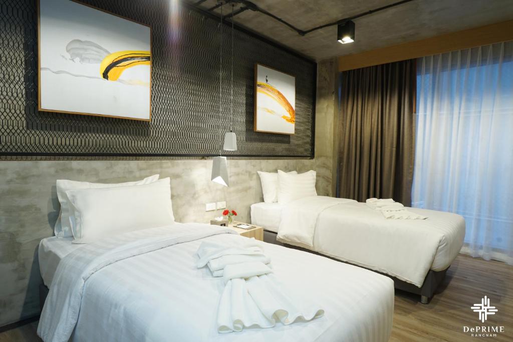 um quarto de hotel com duas camas com lençóis brancos em De Prime Rangnam Hotel em Bangkok