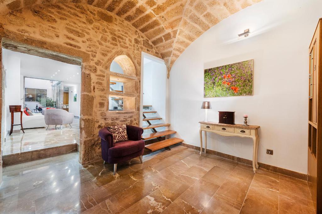 a living room with a chair and a table at Ca Se Predine - Mediterranean Styled Townhouse in Alcudia