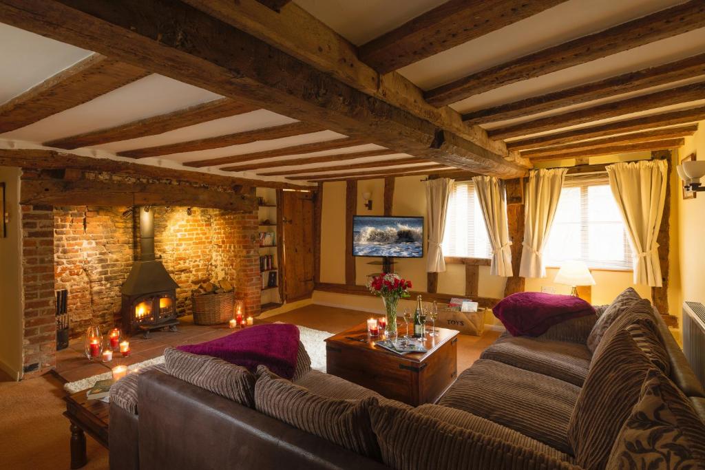 a living room with a couch and a tv at Oak Cottage in Thorndon