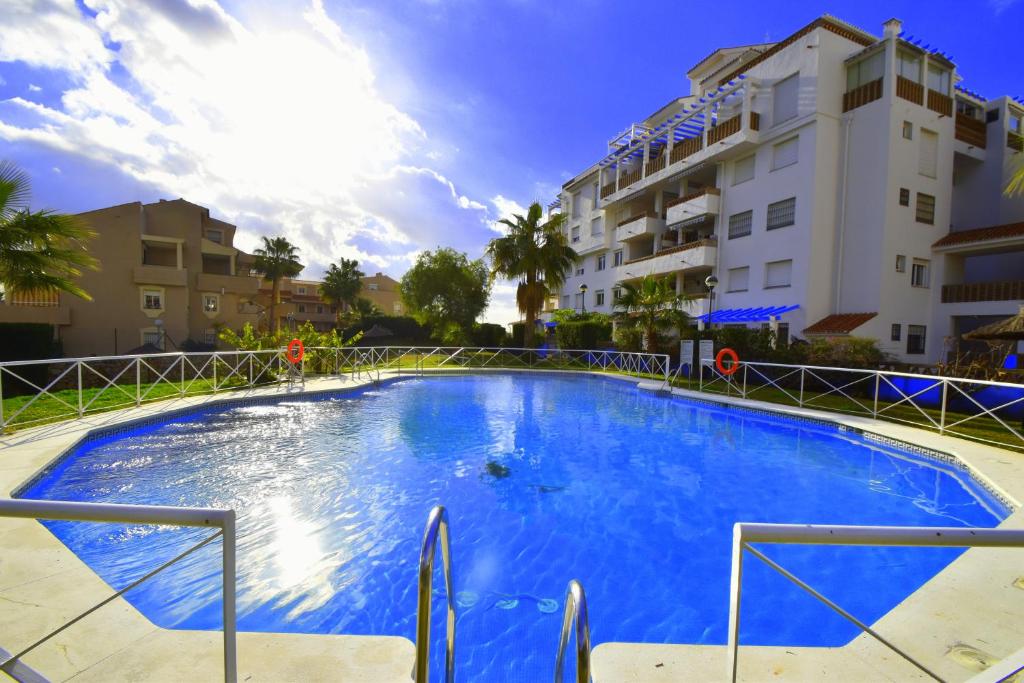 una gran piscina azul frente a un edificio en Reserva del Parque, en Benalmádena