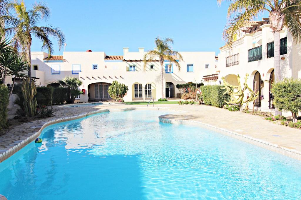 - une piscine en face d'un bâtiment avec des palmiers dans l'établissement Las Casitas de la Playa, à Vera