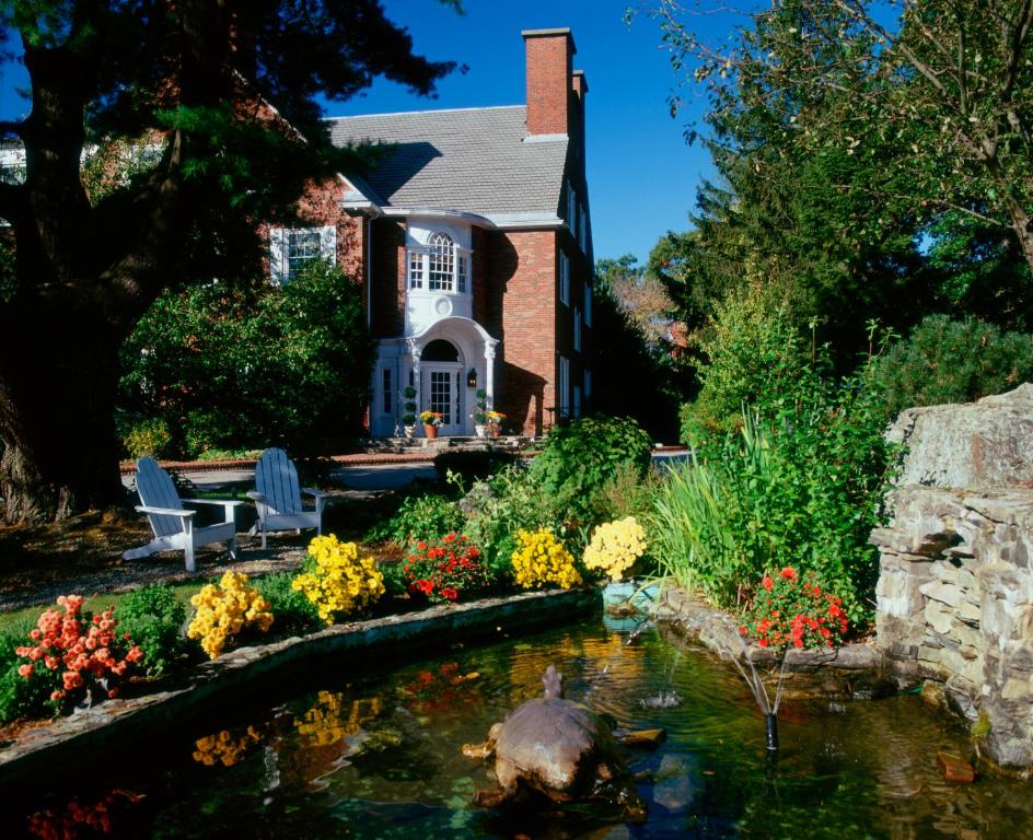 a house with a pond in front of a house at The Spa at Norwich Inn in Norwich