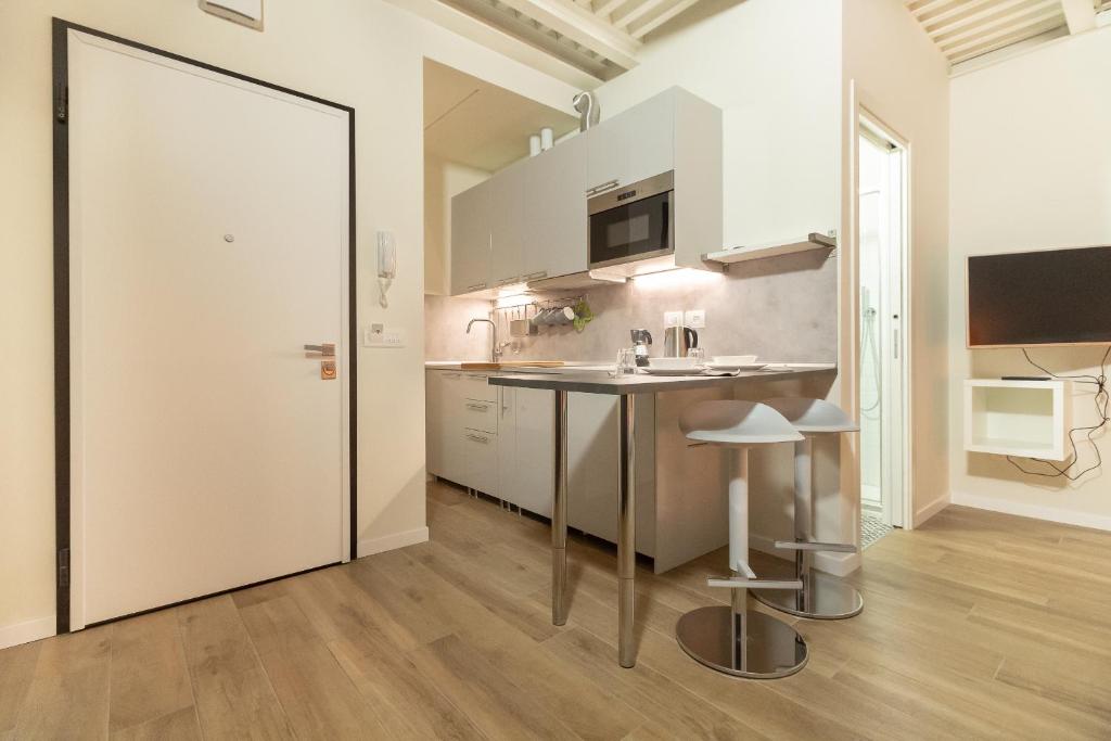 a kitchen with a counter and a table and stool at Alessia's Building- Affori FN in Milan