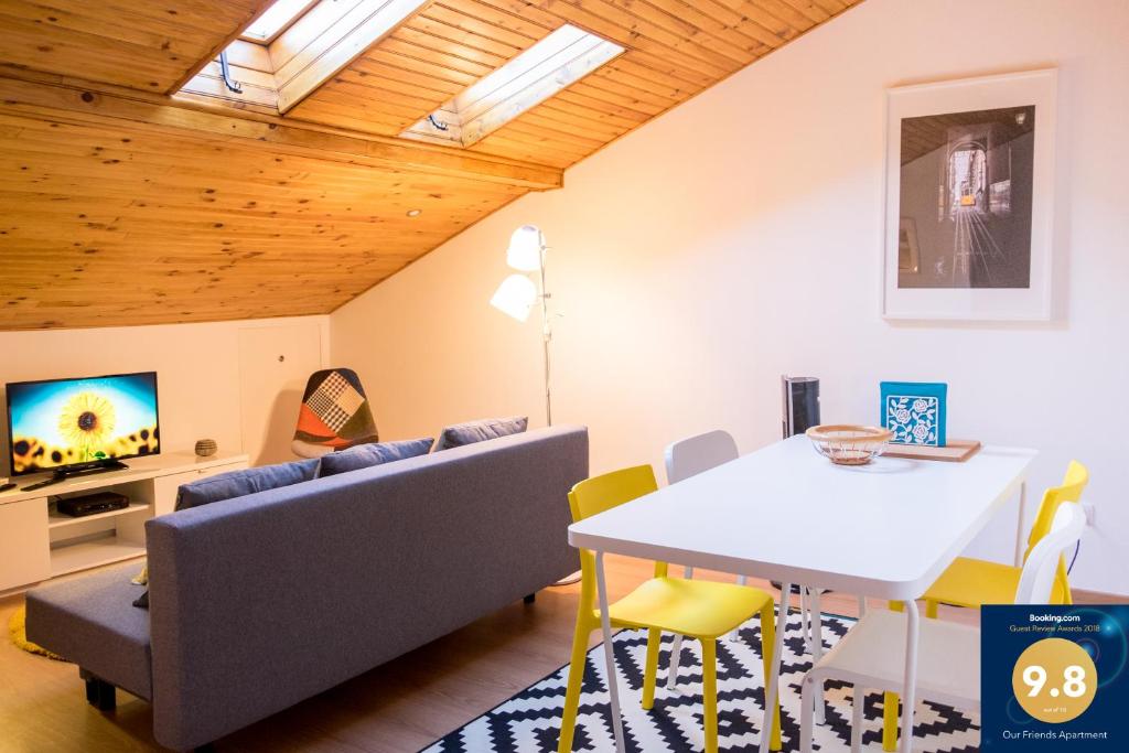 a living room with a table and chairs and a tv at Our Friends Apartment in Lisbon