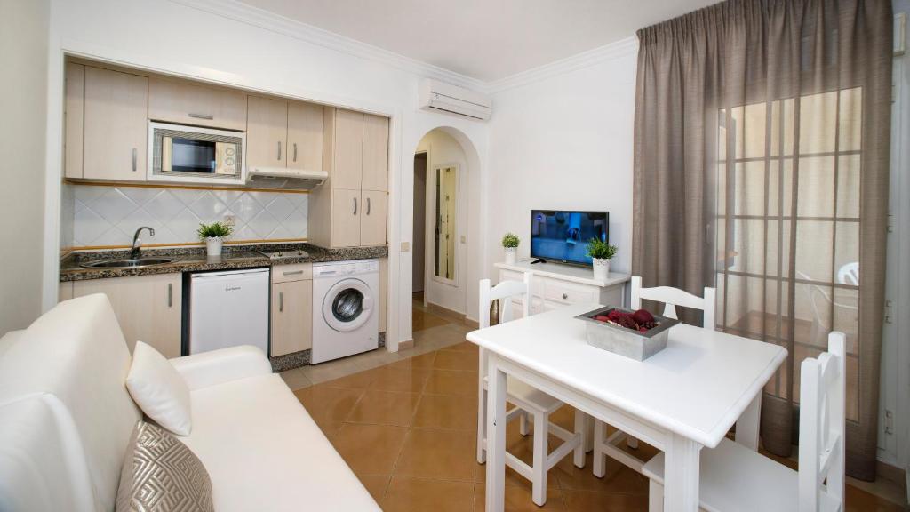 a kitchen and living room with a white table at Leo San Bruno in Isla Canela