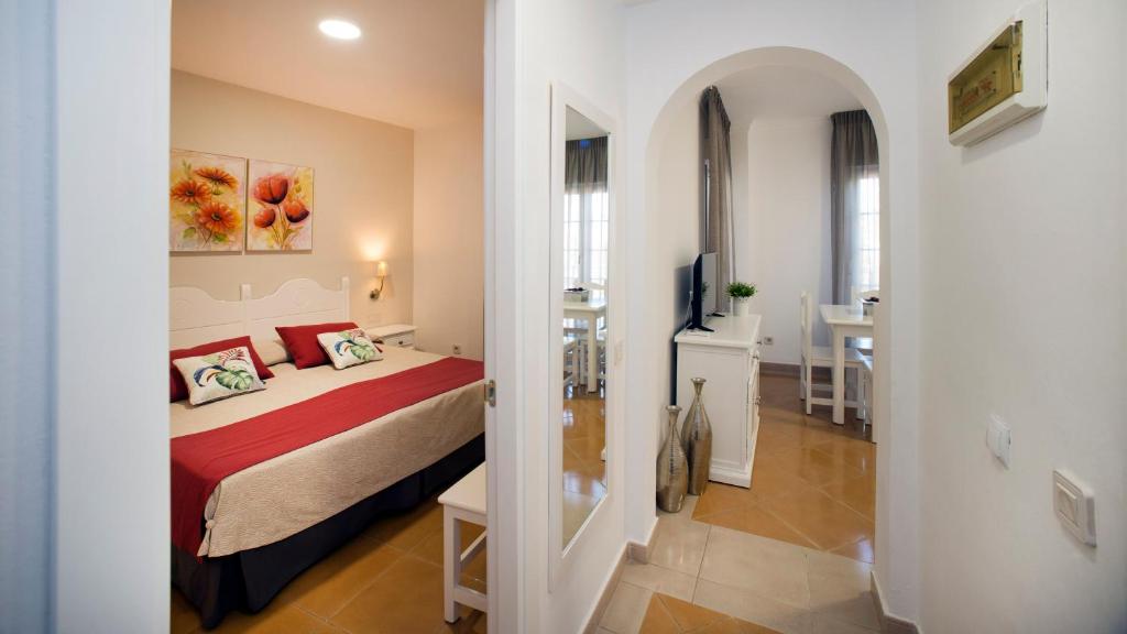 a bedroom with a bed and a room with a table at Leo San Bruno in Isla Canela