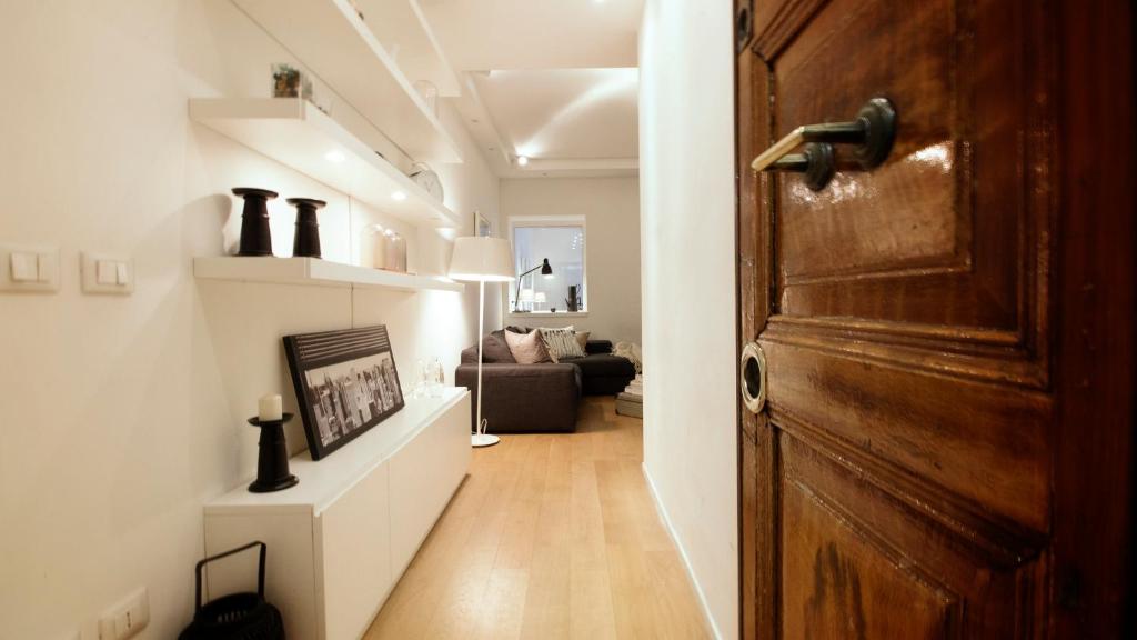 a hallway with a door and a living room at Urbanflat Roma in Rome