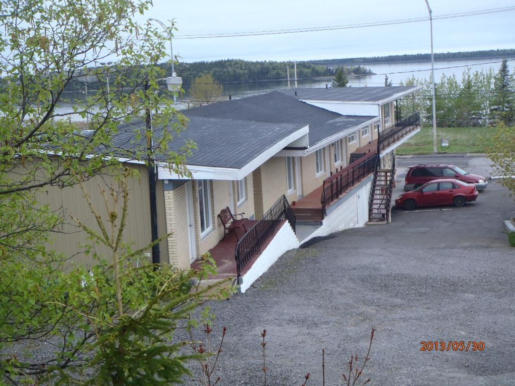 una fila de casas con autos estacionados en un estacionamiento en Motel Lyse, en Rimouski