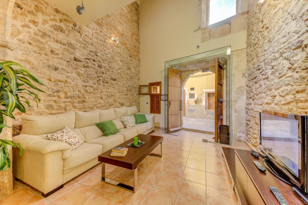 a living room with a couch and a fireplace at Cas Xeremier by Sealand Villas in Alcudia