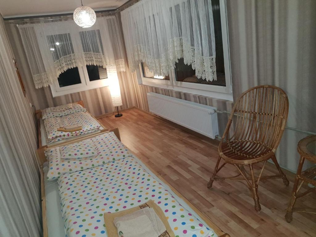 Habitación pequeña con 2 camas y silla en Słoneczny Anioł en Łaziska