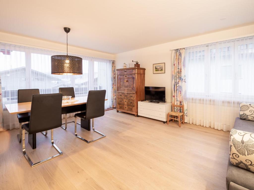 een eetkamer met een tafel en stoelen en een televisie bij LAAX Homes - Casa Zundra in Flims