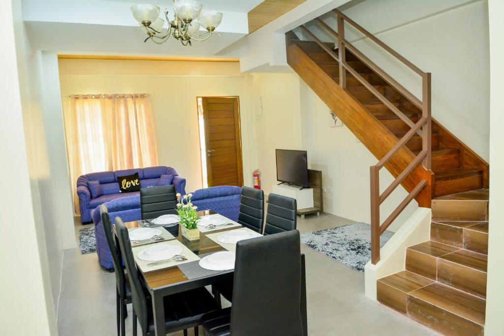 a living room with a table and a dining room at MAILZ HAVEN BEAUTIFL 3BR MODERN APRT NEAR SM DOOR-C in Davao City