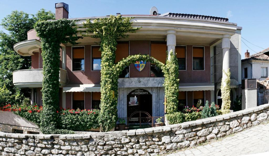 a building with ivy growing on a stone wall at Villa Forum in Ohrid
