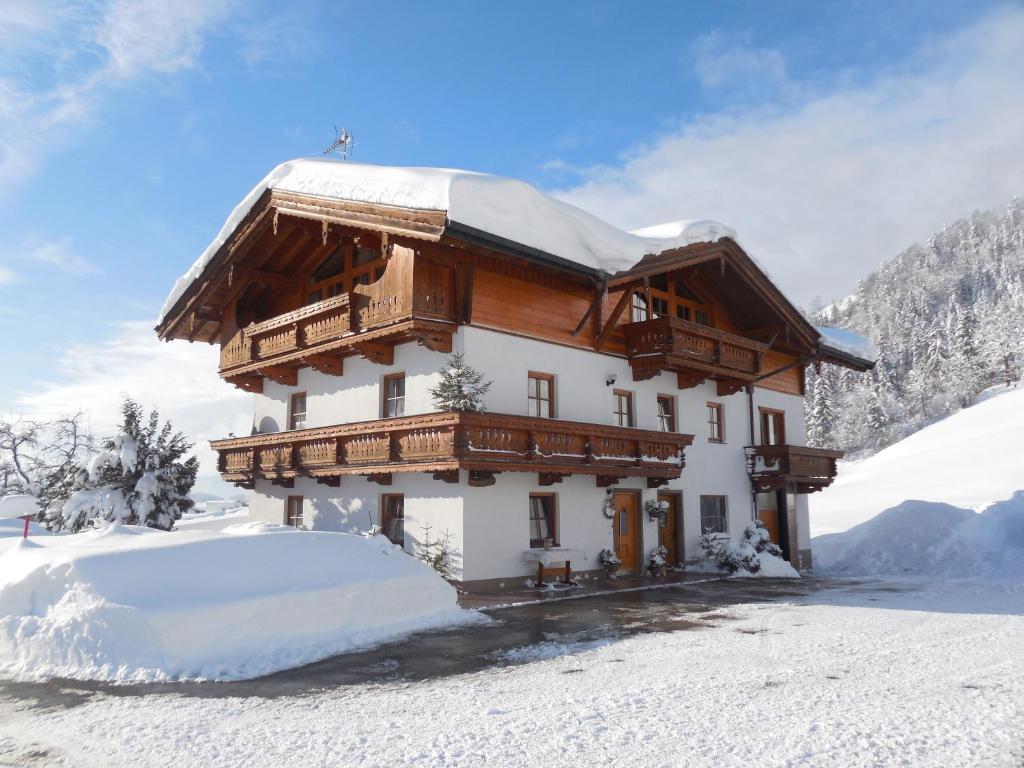 una casa en la nieve con nieve en el suelo en BIO- Bauernhof Obermaurach, en Walchsee