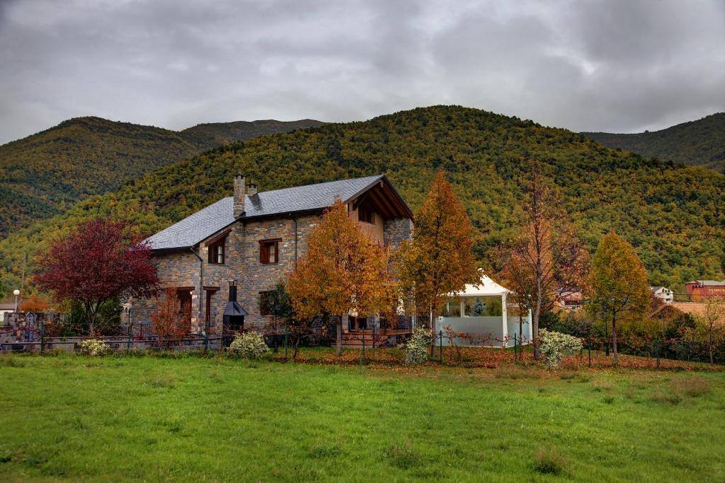 una grande casa in pietra di fronte a una montagna di Casa Rural Villa Gervasio a Fiscal