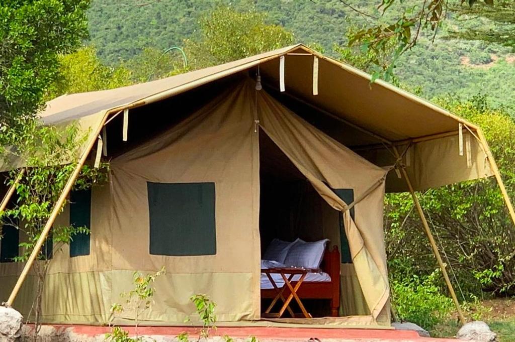 a canvas tent with a bed in the middle at Mara Olodare in Ololaimutiek