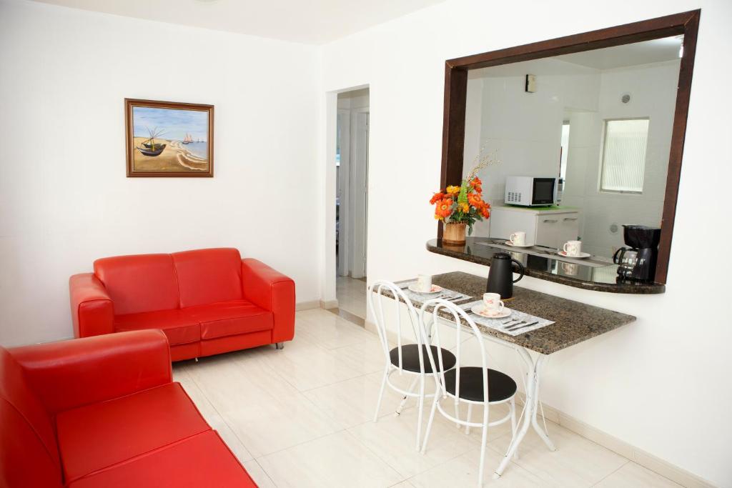 a living room with a red couch and a table at Apartamento 2 quartos in Laguna