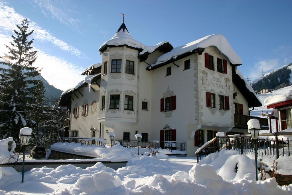 duży biały dom pokryty śniegiem w obiekcie Das Bergschlössl - very special w mieście Sankt Anton am Arlberg