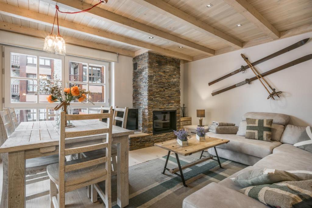 sala de estar con mesa y chimenea en Val de Ruda Luxe 33 by FeelFree Rentals, en Baqueira Beret