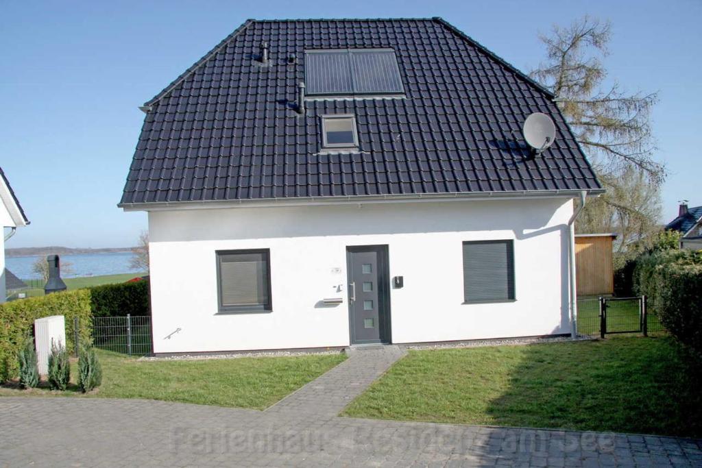 ゲーレン・レビンにあるFerienhaus Residenz am Seeの黒屋根の小さな白い家