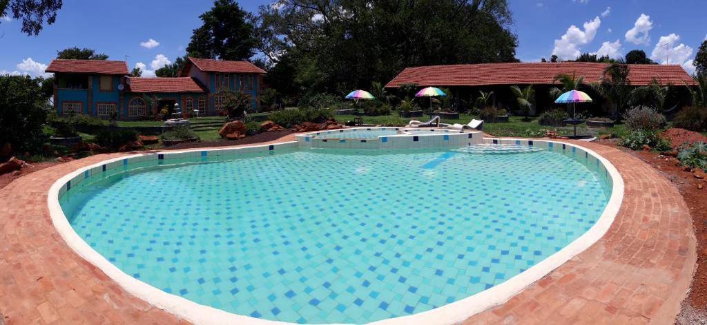 ein großer Pool in der Mitte eines Gartens in der Unterkunft Parque Paraíso das Flores in Holambra