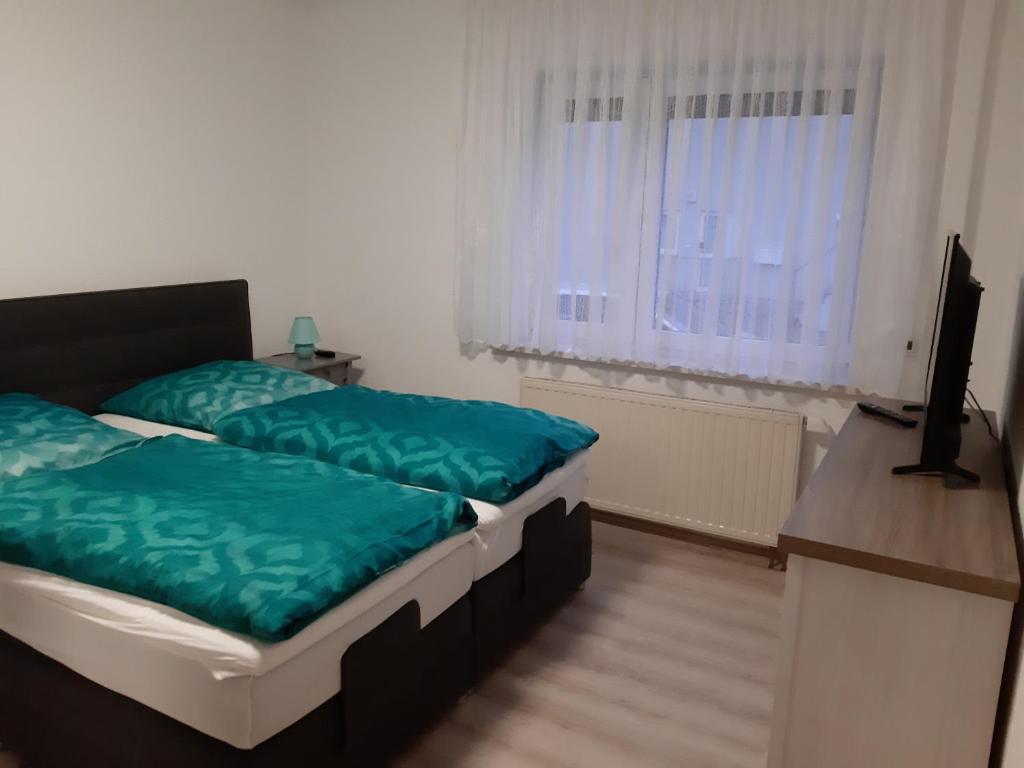a bedroom with two beds and a flat screen tv at Ferienwohnung Elias in Merseburg