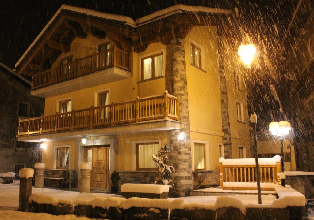 una casa grande en la nieve por la noche en Villa Giuditta Residence, en Gaby
