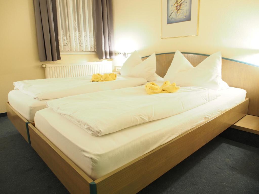two beds in a hotel room with yellow bows on them at Pension Ottendorf-Okrilla in Ottendorf-Okrilla