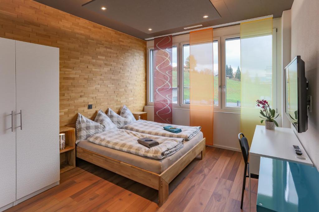 1 dormitorio con cama y pared de ladrillo en Andi's BnB, en Zug