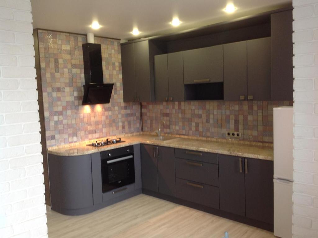 a kitchen with brown cabinets and a large mirror at Квартира у моря in Sochi